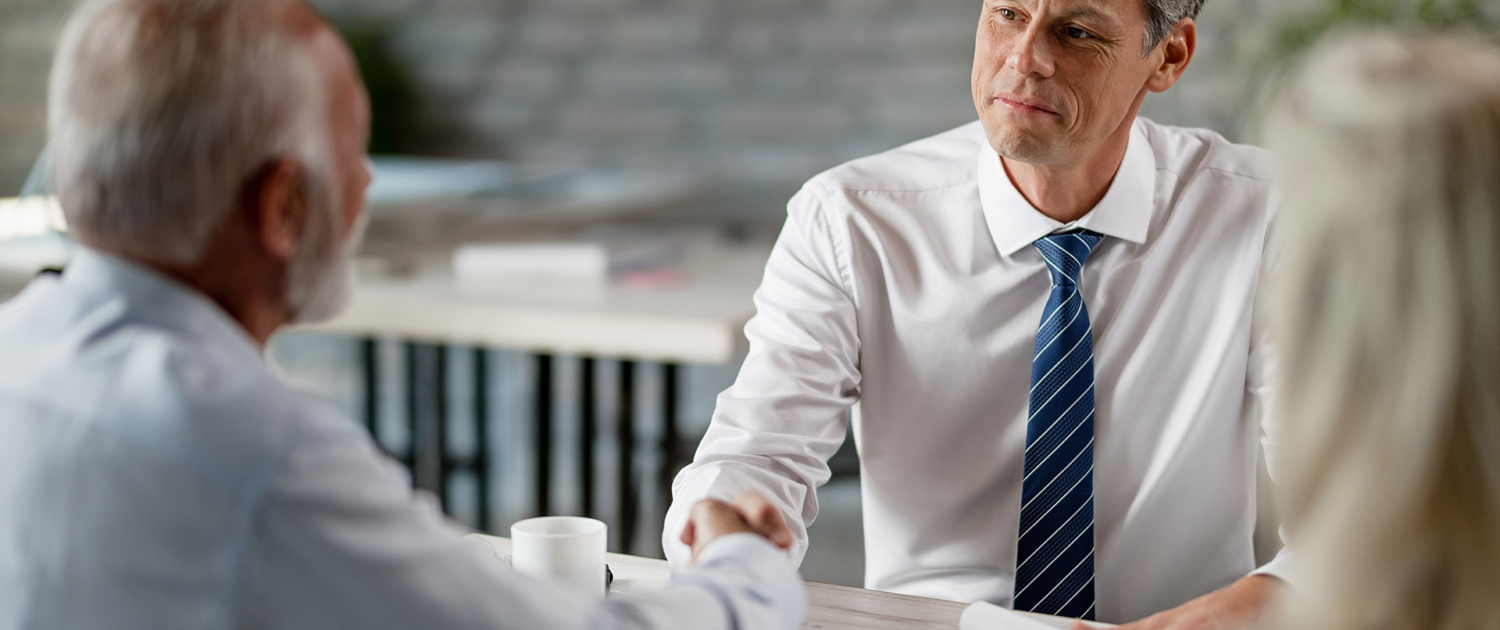 happy-real-estate-agent-senior-clients-shaking-hands-after-successful-meeting-office